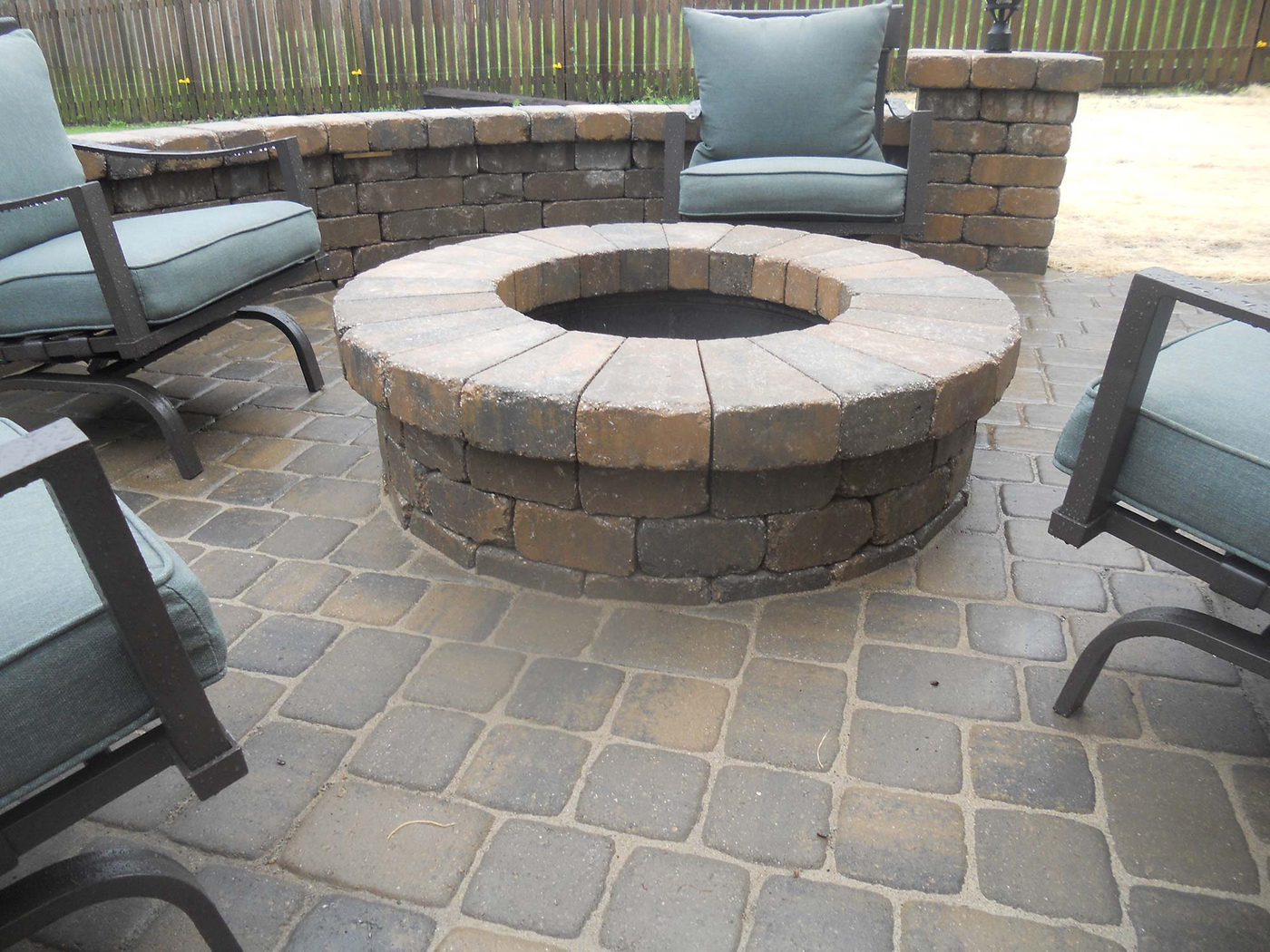 Stone fire pit and patio seating built by Outlook Hardscape