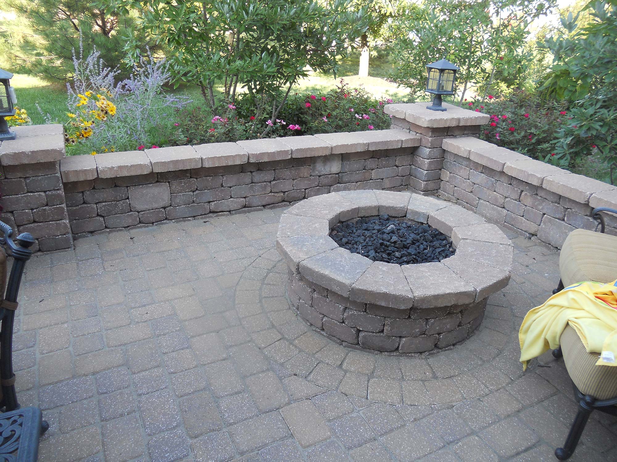 Stone fire pit set into a paver patio built by Outlook Hardscape