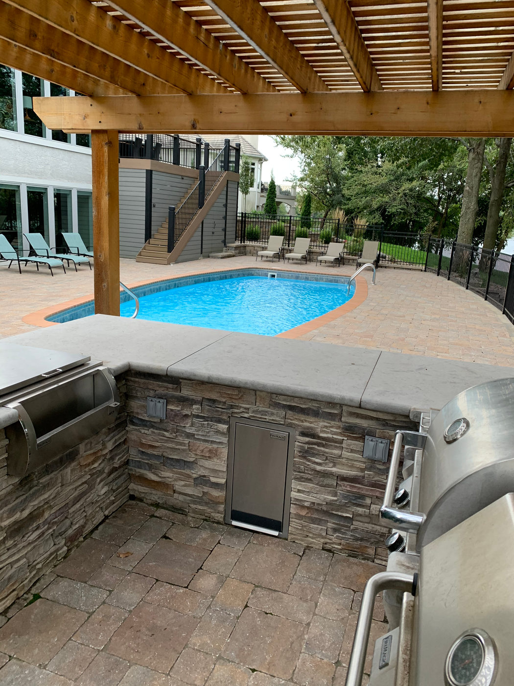 Built-in outdoor kitchen with a stone counter built by Outlook Hardscape