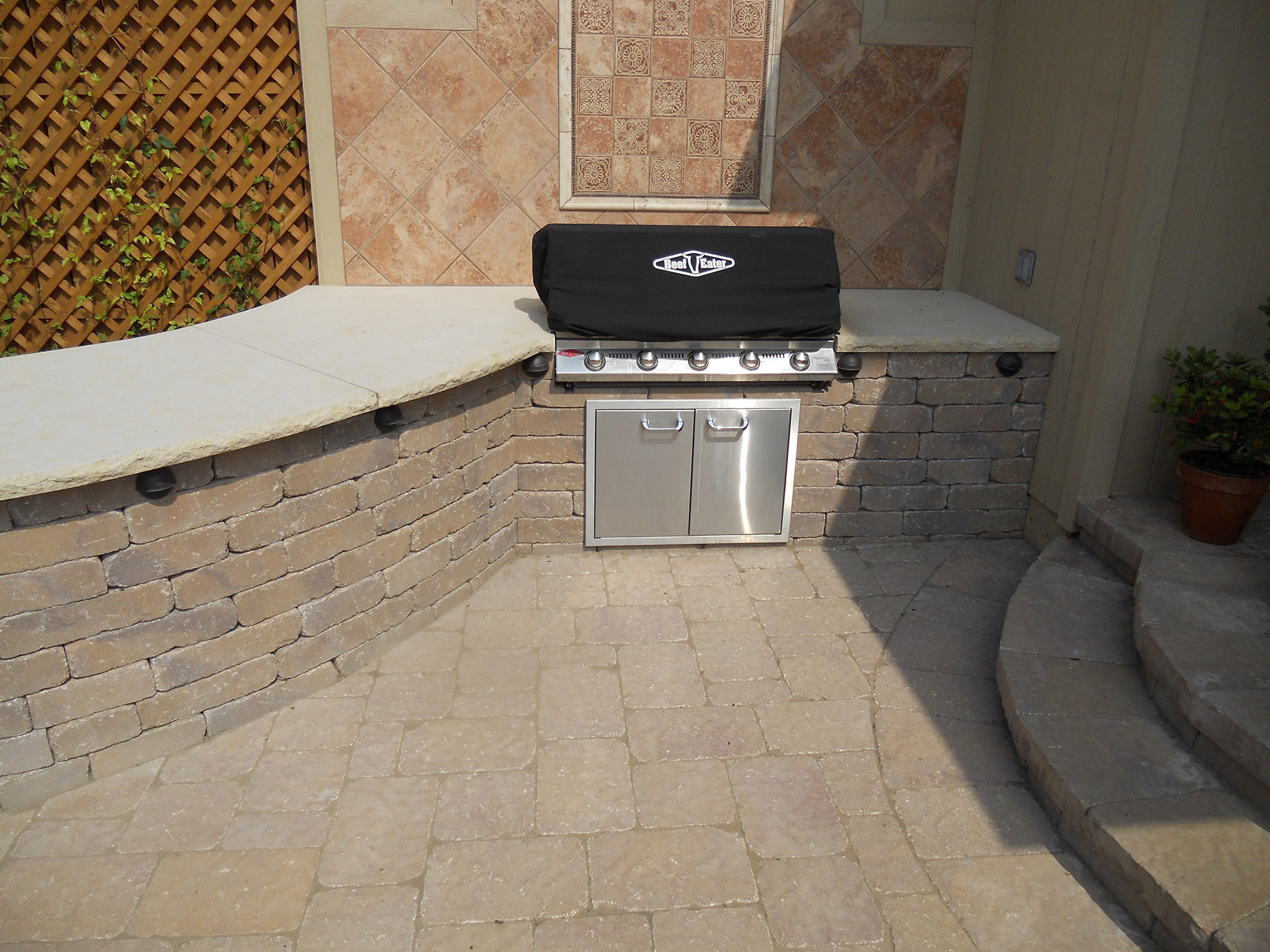 Outdoor kitchen and grill surround in stone and paver